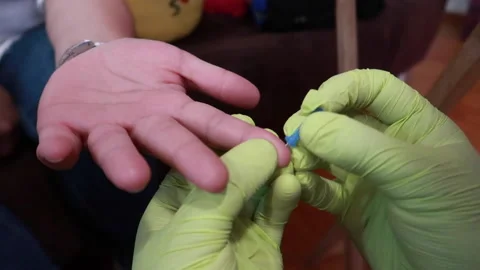 Close up of person's hand pricking finger to do blood test with latex gloves Stock Footage 158703306