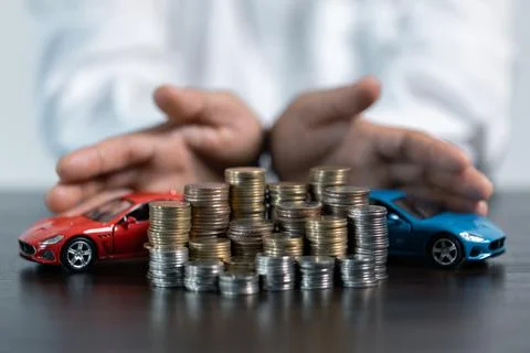 Close-up Of A Person's Hand Protecting Increasing Stacked Coins And Blue Ca.. Stock Photos