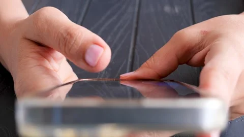 A close-up of a person's hand scrolling on a smartphone Vidéo 285784915
