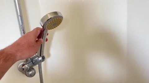 A close-up of a person's hand securing a chrome shower head into an adjusta.. Stock Footage 323001252