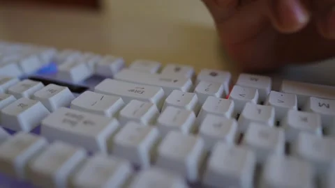 Close-up of a person's hand typing on a white keyboard, focusing on the key.. Stock Footage 320724019