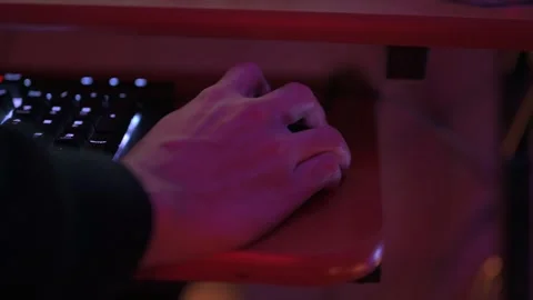 Close up of a person's hand using a computer mouse next to a backlit keyboard, Stock Footage 327684548