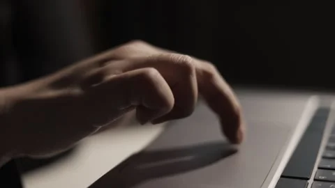 Close-up of a person's hand using a laptop touchpad in low light conditions Stock Footage 339173922