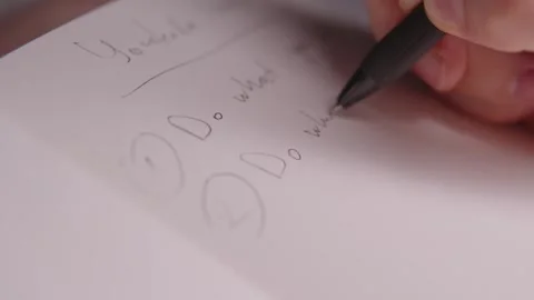 Close up of a person's hand using a pen to write down ideas and brainstorm Stock Footage 328989032