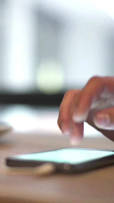 Close-up of a persons hand using a phone in a cafe 스톡 동영상 333621844