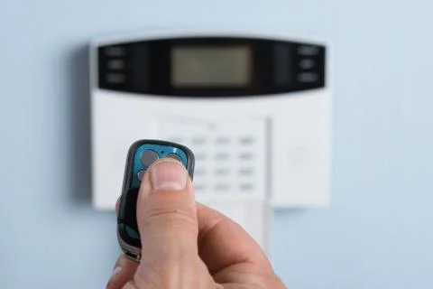 Close-up Of A Person's Hand Using Remote Control To Disarm The Security Syste Foto stock