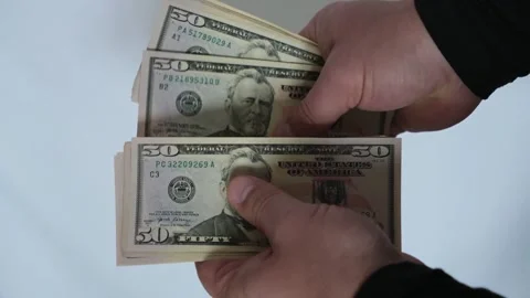 Close-up of a person's hands counting a stack of fifty dollar bills Vídeos de archivo 335041136