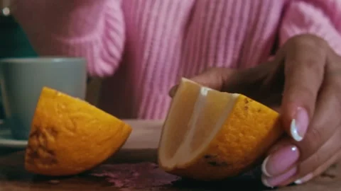 Close-up of a person's hands cutting a bright orange in half with a sharp knife Stock Footage 301276246
