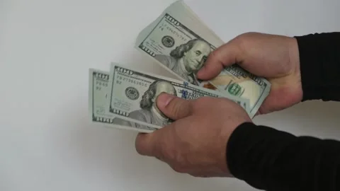 Close-up of a person's hands holding and counting a one hundred dollar bills Vídeos de archivo 335041170