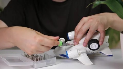 Close-up of a persons hands performing precise electronics repair on a childs Stock Footage 315430702