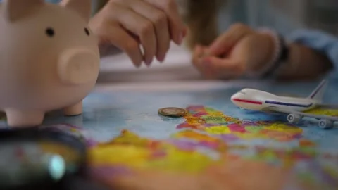 Close-up of a person's hands stacking coins on a world map, illustrating th.. Stock-Footage 344882382