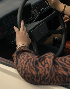 Close-up of a person's hands on the steering wheel of a car, showcasing a fas Fotos de archivo