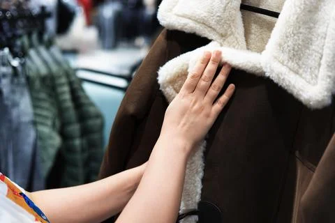 Close-up of a person's hands touching the fluffy white collar of a brown su.. Stock Photos