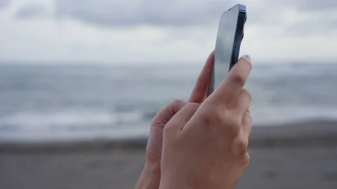 Close-up of person's hands typing on text on new phone, against background of Stock Footage 220119453