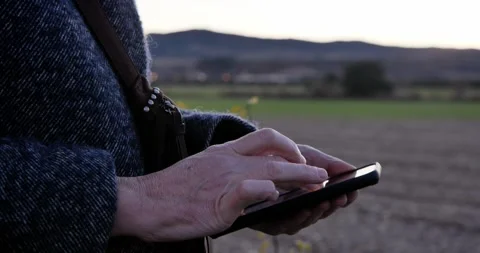 A close-up of a person's hands using a phone against a serene backdrop Stock Footage 329681012