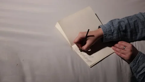 Close-up of a person's hands writing in a notebook with a pen Stock Footage 339177759
