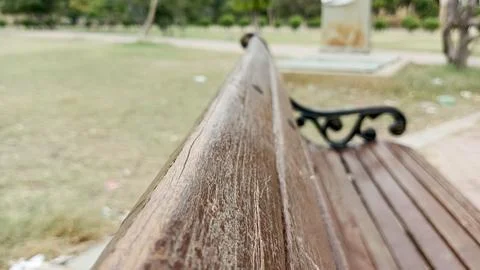 Close up perspective gazing down brown painted wooden slats park bench Stock Photos