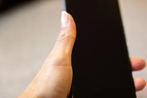 Close perspective of hand grasping smartphone with natural skin tone and subtle Stock Photos