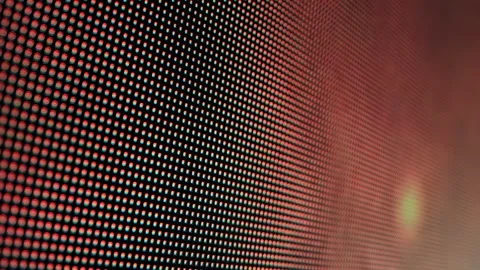 Close-up perspective of LED screen pixels displaying vibrant red and orange Stock Footage 342230938