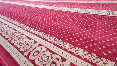 Close perspective of ornate red mosque prayer carpet Fotos de archivo
