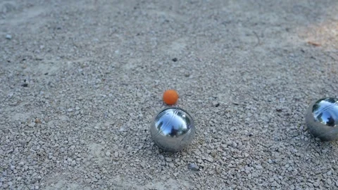 Close-up of petanque balls and a small target ball on gravel during a game. The Stock Footage 284040556