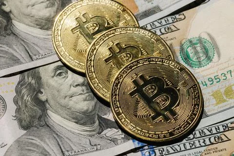 Close-up pf bitcoin on banknotes of one hundred dollars. Exchange US dollars for Stock Photos