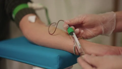 Close-up of phlebotomist drawing blood sample from female patient arm wearing Stock-Footage 325715457