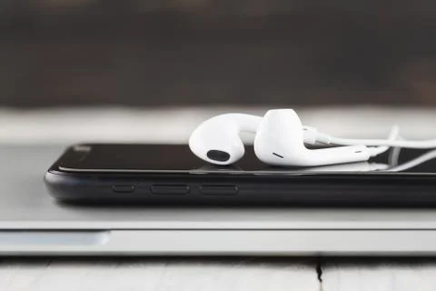 Close-up phone and headphone stack on laptop computer front view Stock Photos