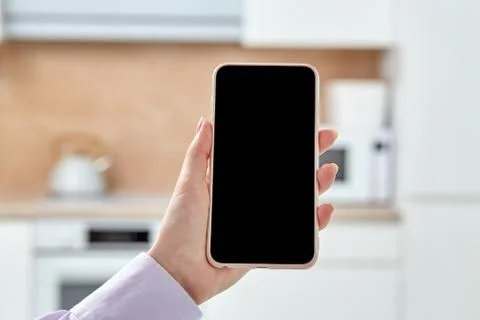 Close-up of a phone with an empty black screen on a light blurry background. Stock Photos