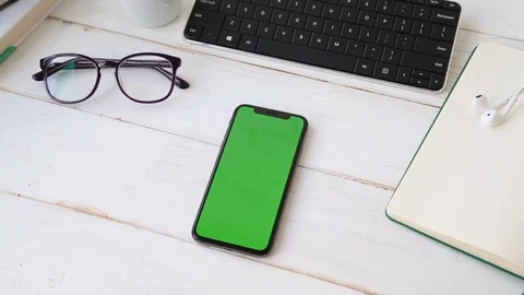 Close Up of Phone With Green Chroma Key Screen on White Office Wooden Table Stock Footage 109604422