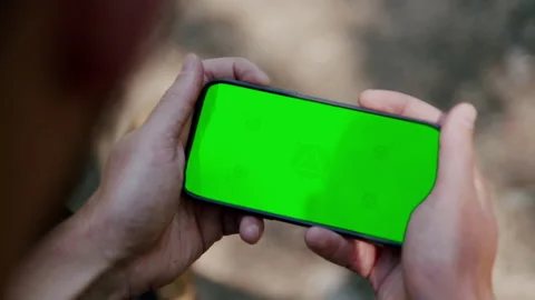 Close-up of phone screen with green screen, man holding a phone 4K. Stock Footage 234571929