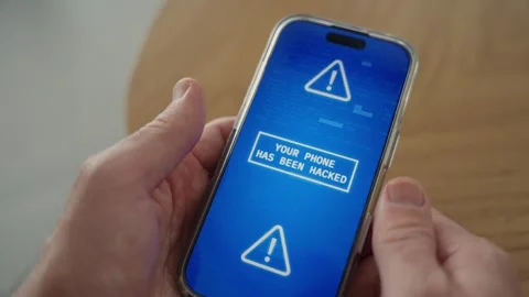 Close up on phone screen held by person with screen warning of cyber hack attack Stock Footage 329378700