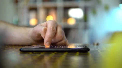 Close-up, the phone is on the table, the guy will scroll the news feed. On a Stock Footage 127349947