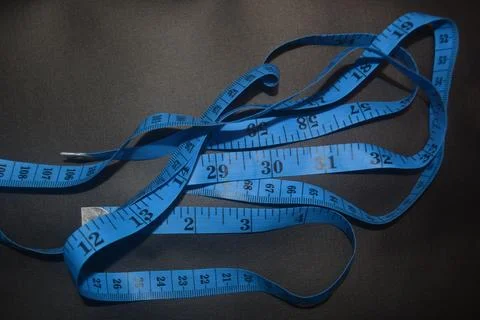 Close up photo of blue sewing meter isolated on black background Stock Photos