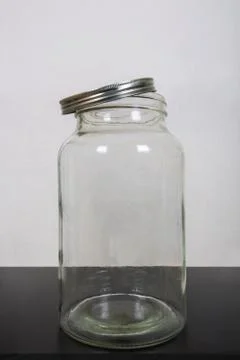 Close up photo of an empty jar, on the table, with a metal lid open isolated  Fotos de archivo