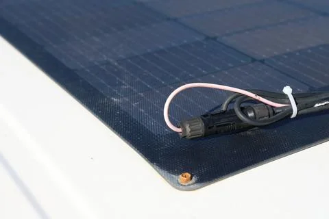 Close-up photo of a flexible solar panel installed on the roof of a white cam Stock Photos