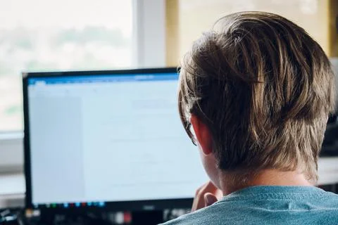 Close-up photo of guy in computer working at home. Back view Stock Photos