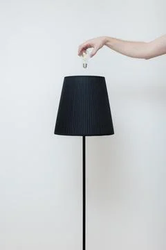 Close-up photo of A hand changes a light bulb in a stylish loft lamp from the Stock Photos