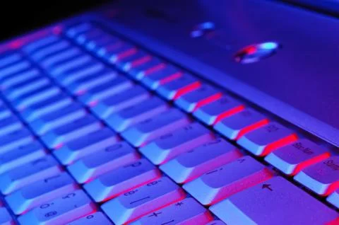 Close-up photo of the keyboard of an open notebook; blue red tone Stock Photos