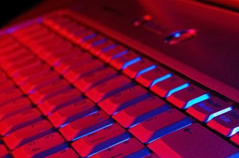 Close-up photo of the keyboard of an open notebook; blue red tone Stock Photos