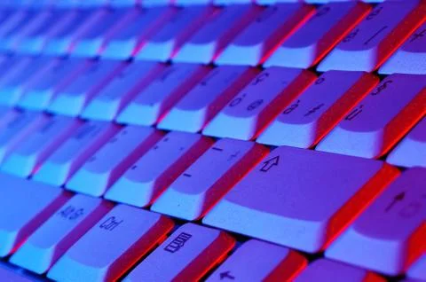 Close-up photo of the keyboard of an open notebook; blue red tone Stock Photos