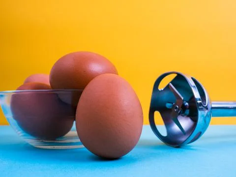 Close-up photo of some brown eggs with a mixer. Stock Photos