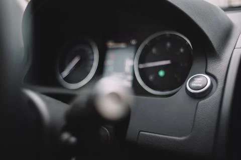 Close up photo of start-stop button in car. Selective focus, blurred dashboar Stock Photos