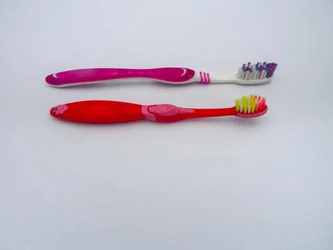 A close-up photo of two types of toothbrushes against a white background. Stock Photos