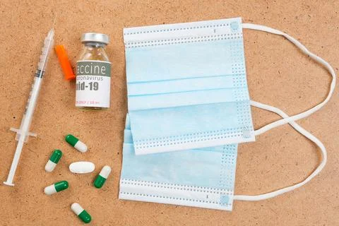 Close up photo of virus protective objects medical masks with a vial of vaccine Stock-Fotos