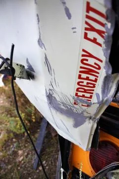 A close up photo of a wrecked school bus with the door twisting off Stock-Fotos