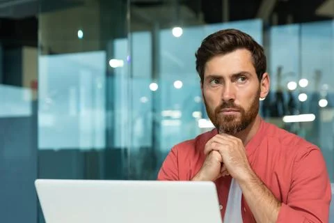 Close-up photo. A young male programmer, designer, freelancer in a red shirt who Foto stock