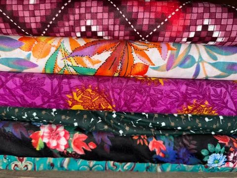 Close up photograph captures a stack of folded cotton fabrics, featuring an a 写真素材