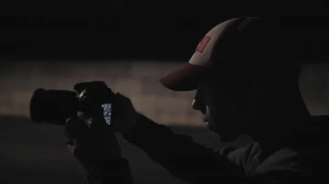 Close up of Photographer viewing camera at night Stock Footage 60268107
