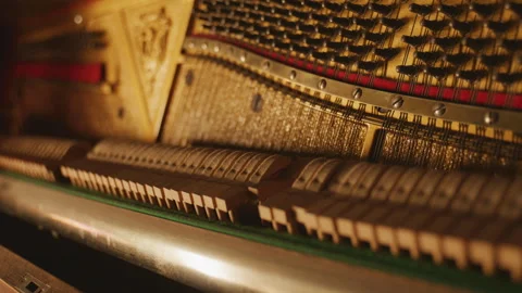 Close-up of piano hammers striking strings inside an upright piano with warm Stock-Footage 326024970